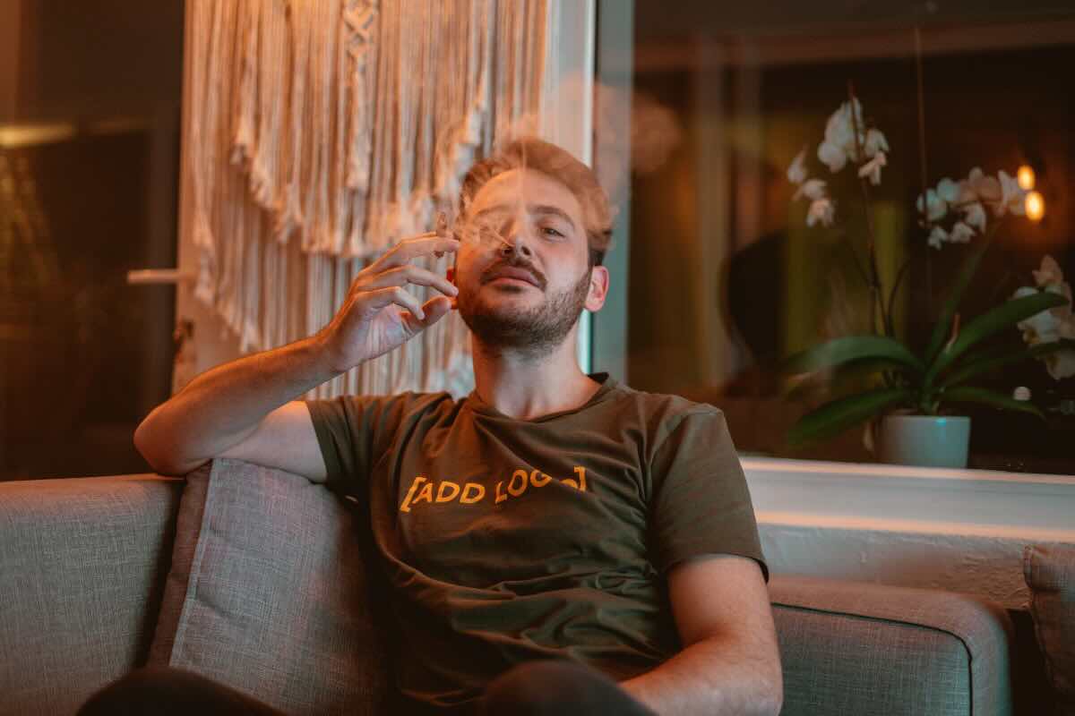 uomo che fuma sul divano