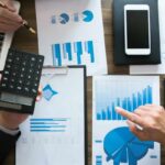 fogli con grafici, calcolatrice, smartphone