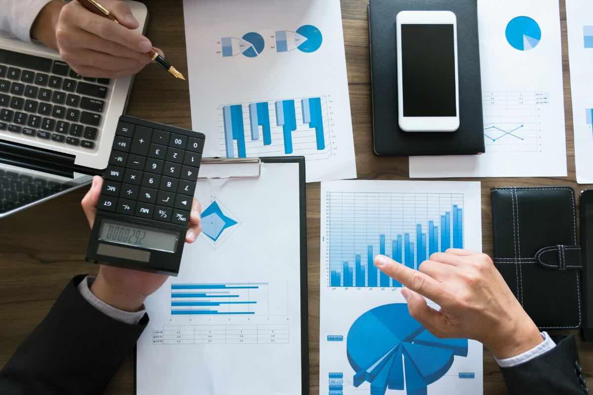 fogli con grafici, calcolatrice, smartphone