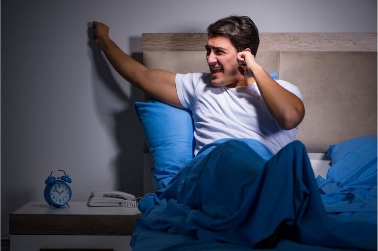 Ragazzo nel letto bussa sul muro, infastidito