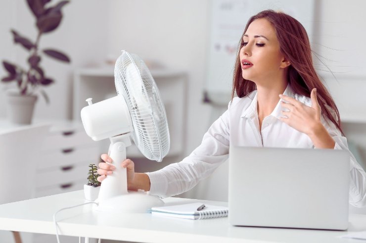 donna con pc e ventilatore