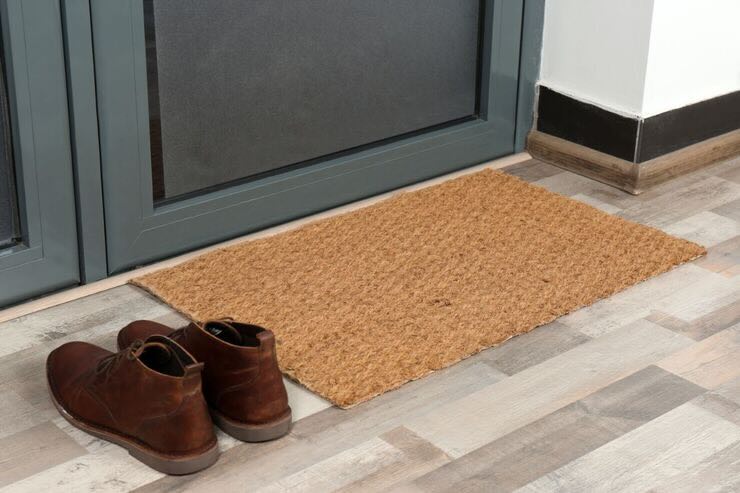 Scarpe vicino tappeto fuori dalla porta