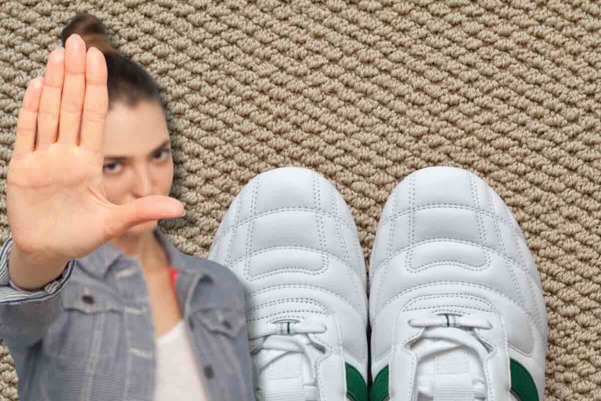 Donna fa stop, scarpe bianche sul tappeto