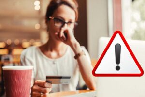 donna con bancomat alla mano e simbolo attenzione