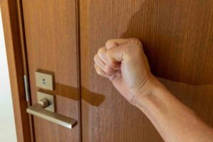 mano che bussa sulla porta
