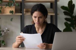 Donna preoccupata legge un documento