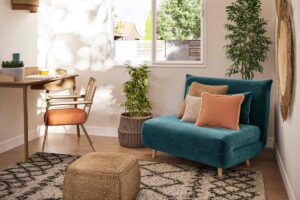 Divanetto pieghevole in velluto Maisons du Monde nell'angolo di una stanza vicino alla scrivania
