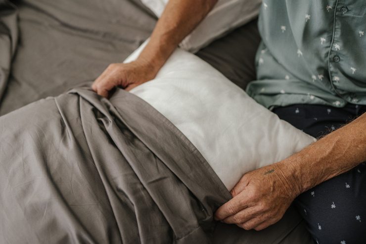 Persona mette una federe tortora a un cuscino