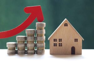 Miniatura casa in legno e monete risparmiate