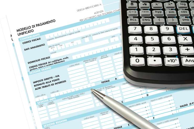 foglio di documento con cui fare calcoli e calcolatrice e penna