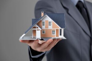Persona tiene in mano un modellino di una casa