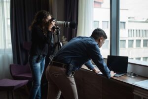 Coppia spia il vicino di casa con computer e macchina fotografica