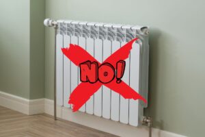 Un termosifone attaccato con una croce sopra che ha scritto sopra "NO!"