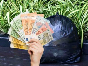sfondo sacco rifiuti e mano con banconote euro