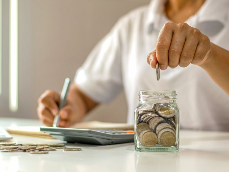 persona che fa calcoli e accumula monete euro