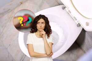 donna che pensa, bagno e punti interrogativi