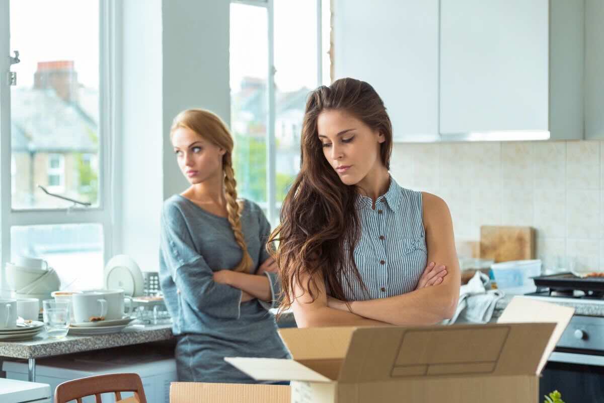 Due donne in casa, una davanti scatoloni, aria pesante fra loro