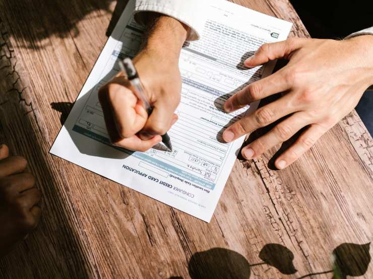 mani che firmano documento