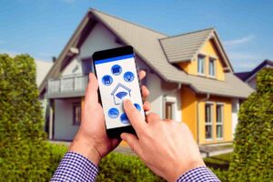 cellulare in mano davanti a una casa