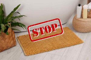 un bagno con vasca con un tappeto da bagno tradizionale e una scritta in primo piano "Stop"