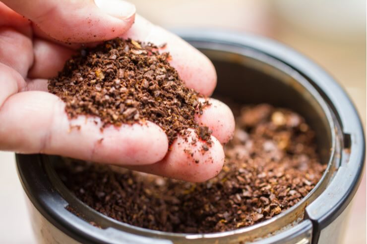 barattolo e mano con fondi di caffè