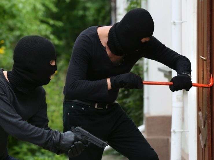 ladro che tenta di forzare la serratura