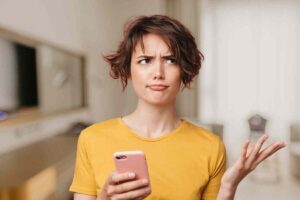 Donna perplessa al cellulare
