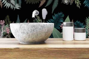 lavabo bagno da appoggio su mensola in legno e dietro un paraschizzi jungle