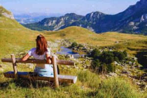 donna seduta su panchina in montagna