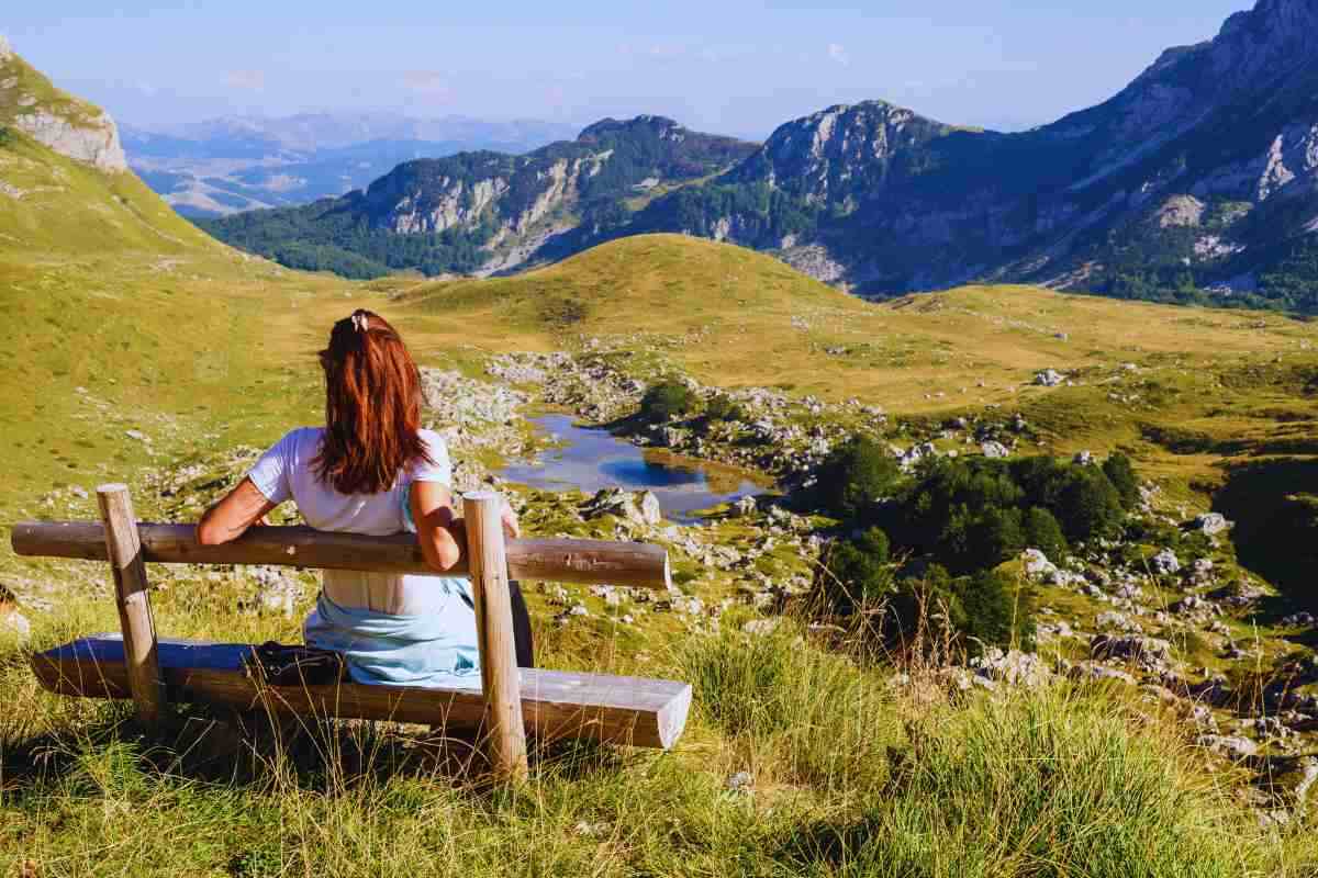 donna seduta su panchina in montagna
