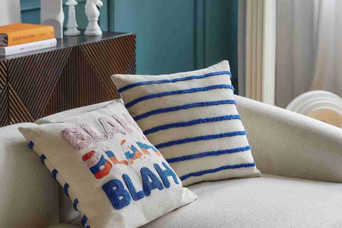 divano con due cuscini della collezione Westwing con scritte