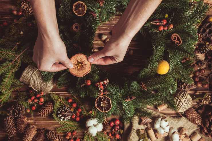 Una persona che compone una ghirlanda natalizia