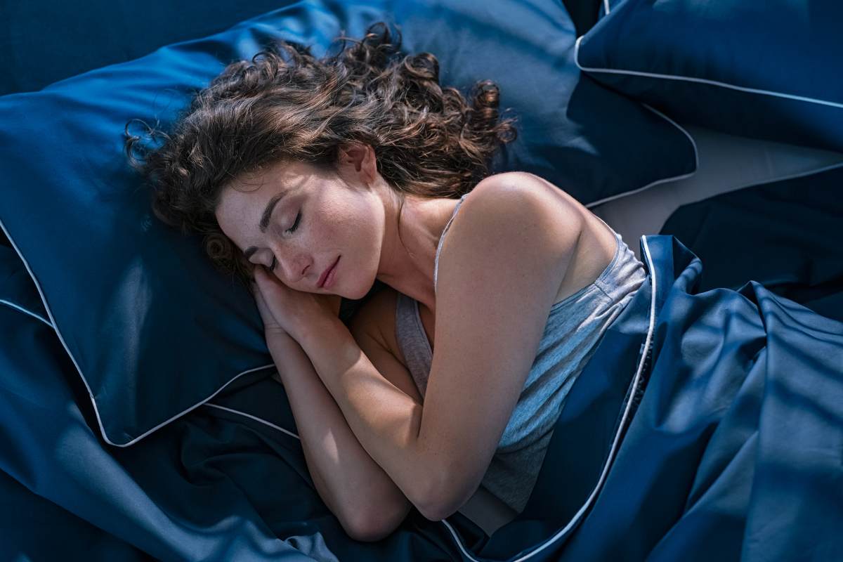 Una ragazza che dorme felice sul proprio letto