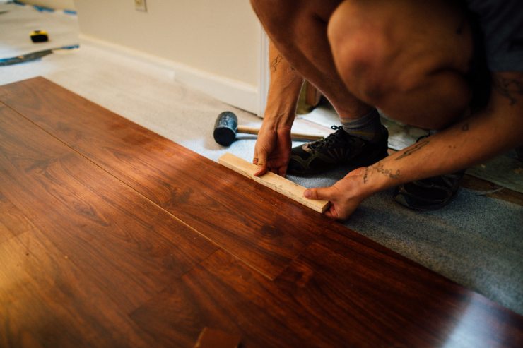 Un operaio che sta montando un pavimento 