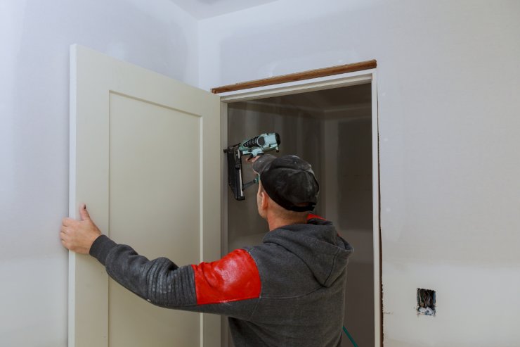 un uomo che sta installando una nuova porta