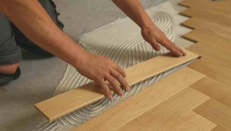mani che posano il parquet