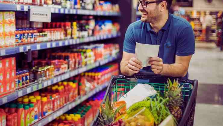 uomo con foglio in mano in supermercato 