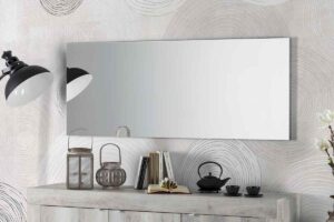 Una delle specchiere led Mondo Convenienza sulla parete di un soggiorno sopra la madia
