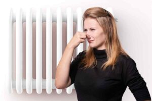 Donna si tappa il naso e termosifone