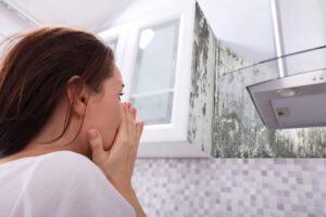 Muffa in cucina e ragazza disperata