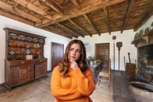 Una casa vecchia ed una ragazza in primo piano pensierosa