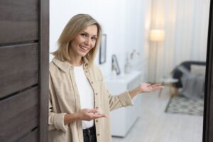 Una donna che con un sorriso accoglie in casa