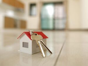 sfondo casa ammobiliata in primo piano casetta portachiavi e chiavi