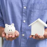 uomo con salvadanaio e casa in mano