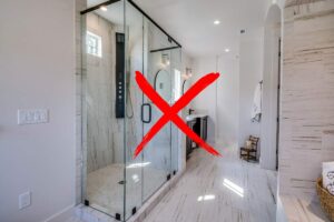 Un bagno con un box doccia ed una croce in primo piano