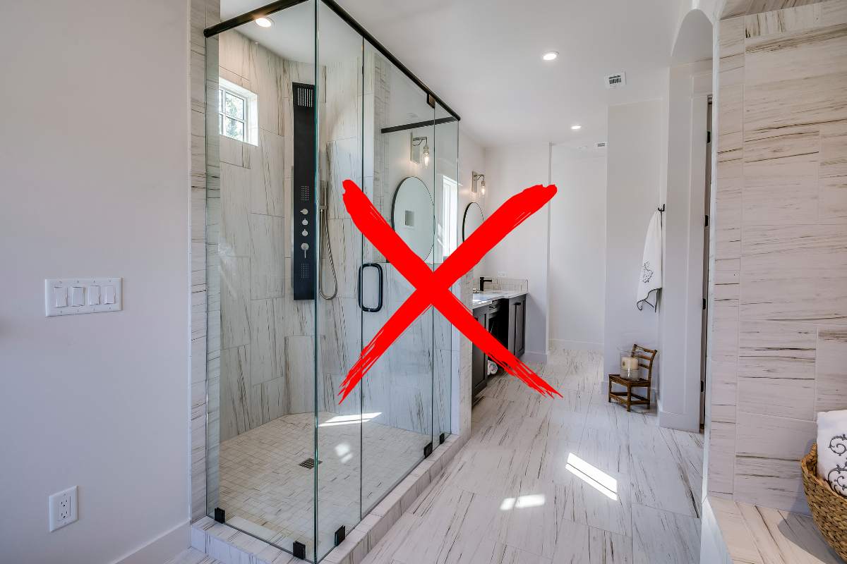 Un bagno con un box doccia ed una croce in primo piano