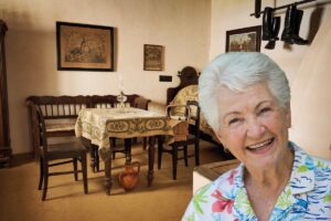 una casa vecchia come sfondo ed una nonna in primo piano