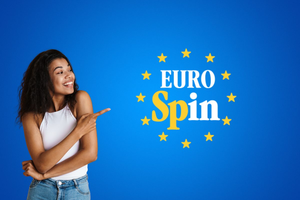 Una ragazza che indica il logo del supermercato "Eurospin"
