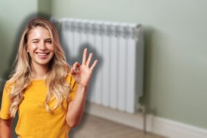 termosifoni in casa e donna sorridente che fa ok con le mani