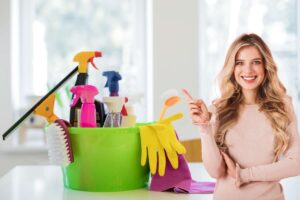 secchio con detersivi e donna felice